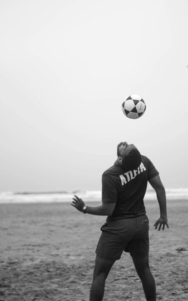 Man on Shore Doing Soccer Trick